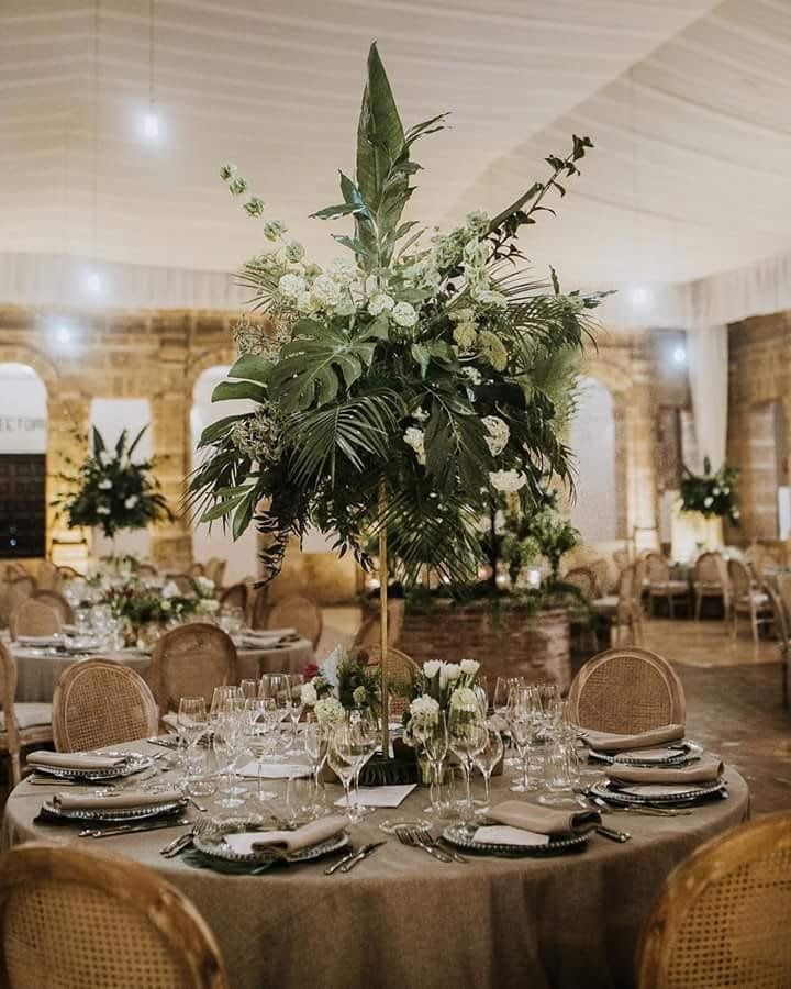 Elegante mesa de recepción de boda con centro de mesa floral.
