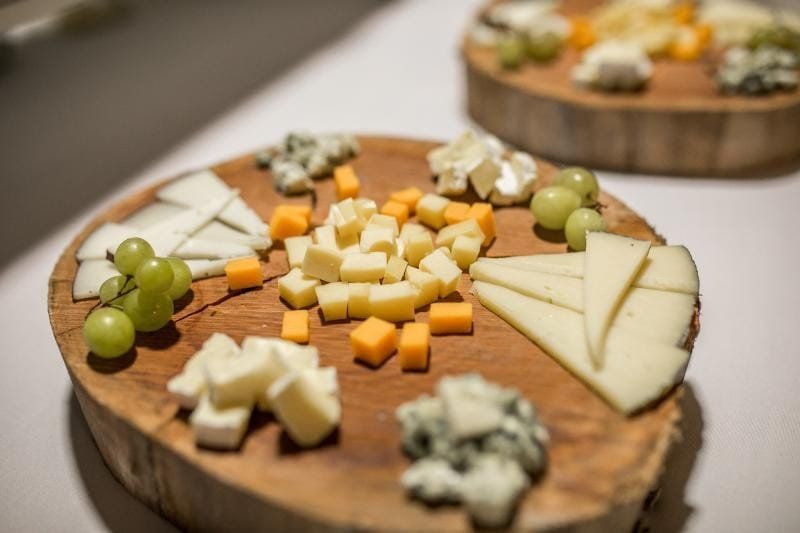 Queso y uvas dispuestos en bandejas de madera.