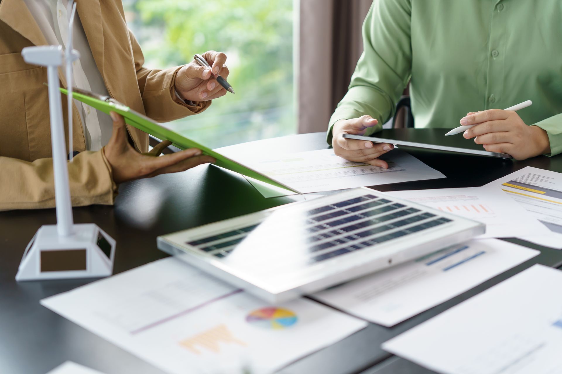 Deux personnes assises à une table discutant autour de graphiques