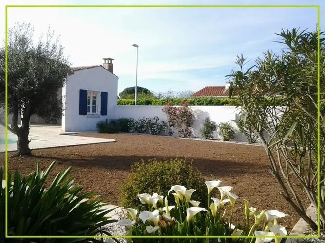 Maisonnette blanche aux volets bleus, petit jardin et ciel ensoleillé
