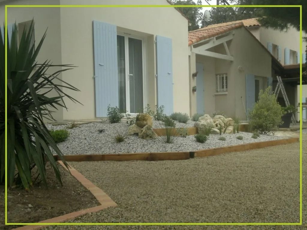Extérieur d'une maison avec volets bleu clair, aménagement paysager en gravier et palmier