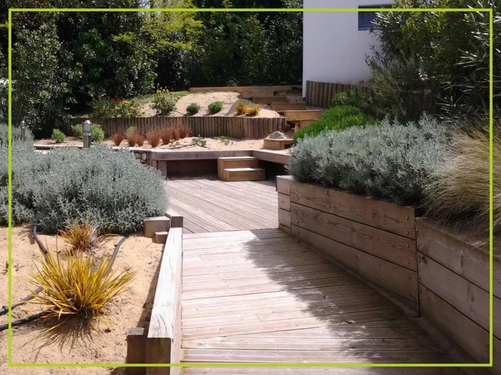 Allée en bois et parterres surélevés agrémentés de verdure dans un jardin paysager