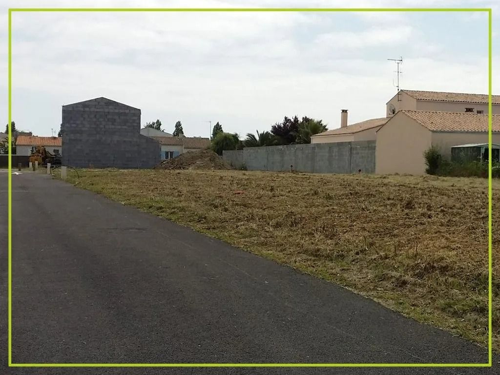 Route longeant un terrain vague, avec des bâtiments en arrière-plan