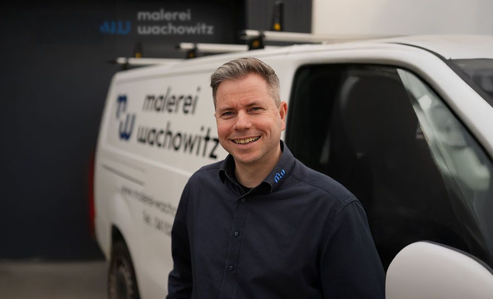 Ein Mann steht vor einem weißen Lieferwagen.