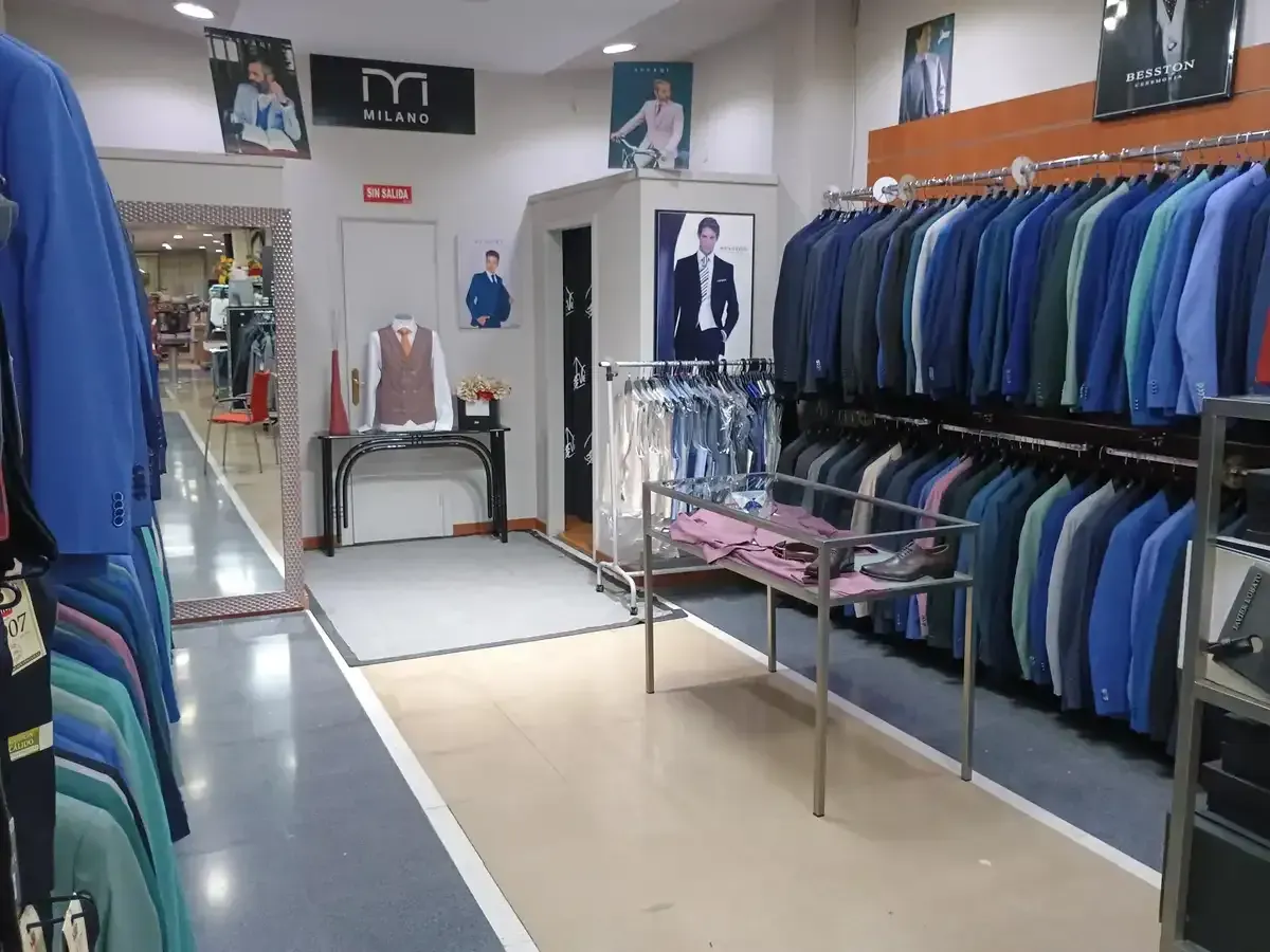 Hombres con trajes azules, algunos con corbatas y ramilletes, caminando al aire libre.