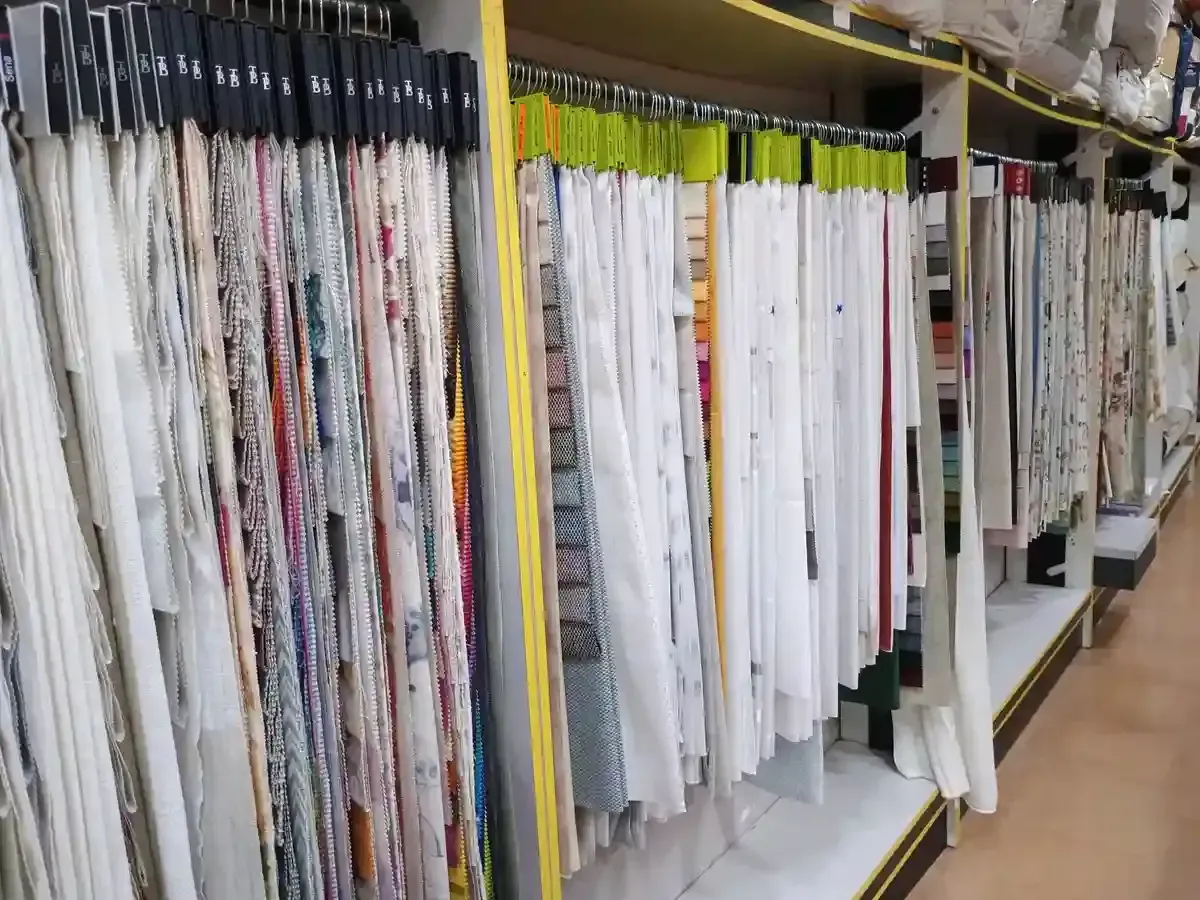 Primer plano de cortinas de colores: blanco, diamante naranja, textura natural y estampado azul.