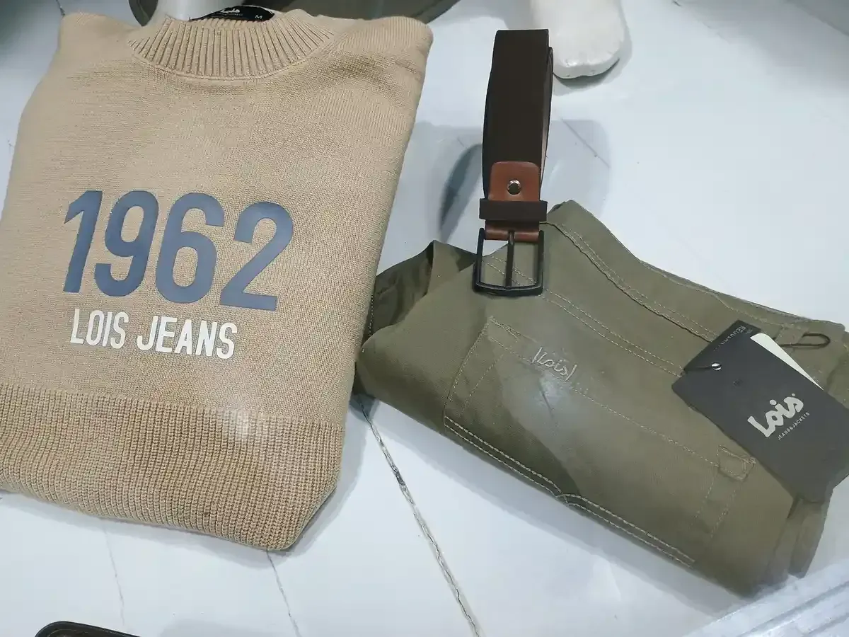 Accesorios de hombre sobre superficie de madera: sombrero, gafas, reloj, pajarita, camisa y estuche para gafas de sol.