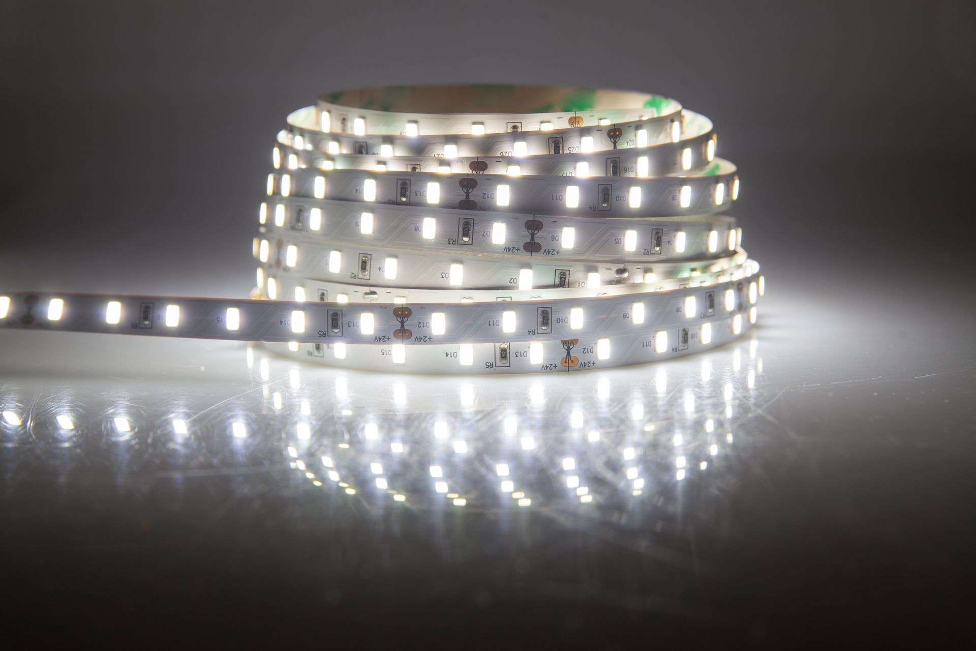 Un rollo de tira de luces LED blancas sobre una superficie blanca.