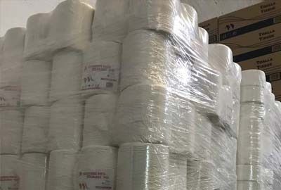 Un almacén lleno de muchos rollos de papel higiénico envueltos en plástico.