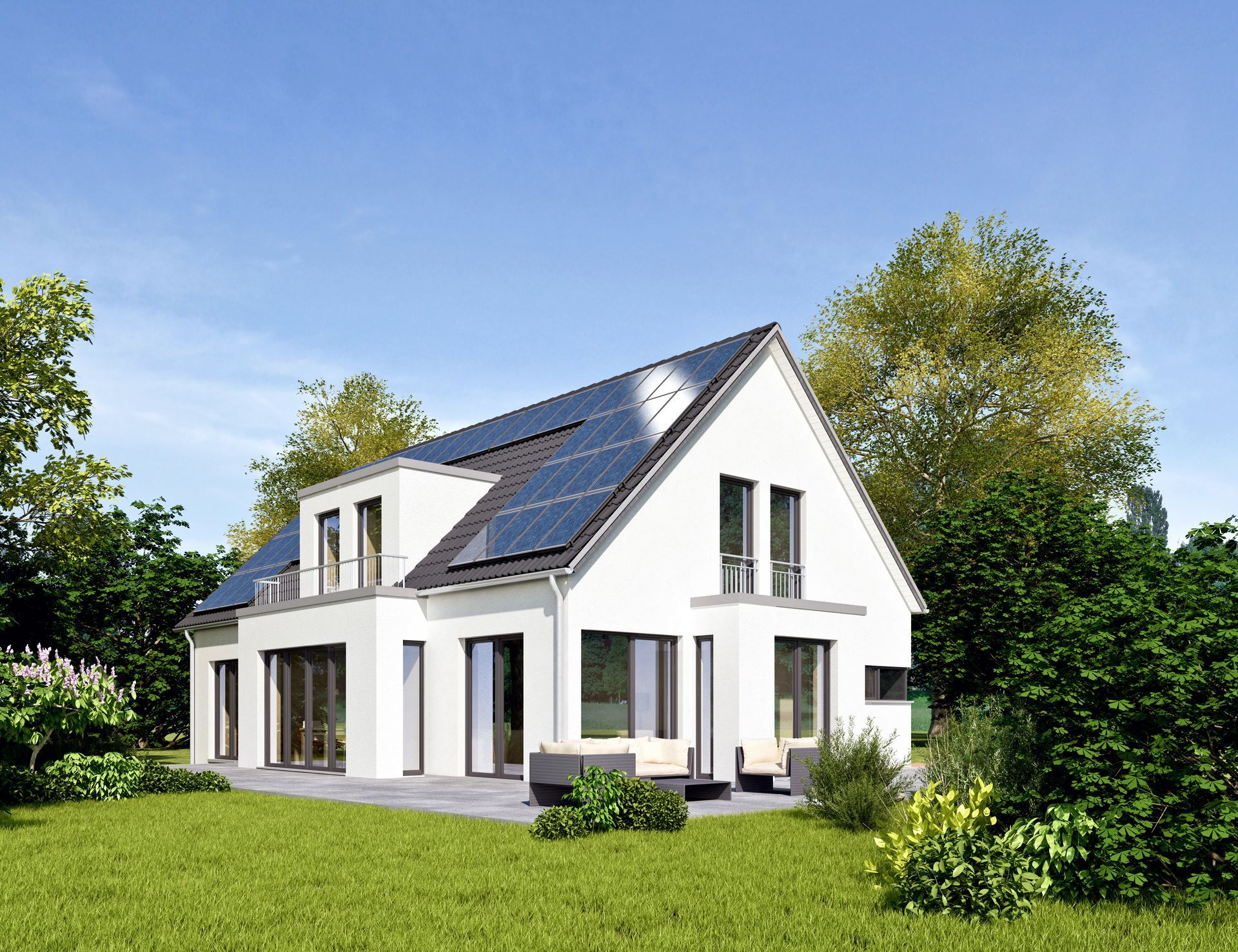 Maison blanche avec panneaux solaires sur le toit, entourée d'herbe verte et d'arbres par une journée ensoleillée.