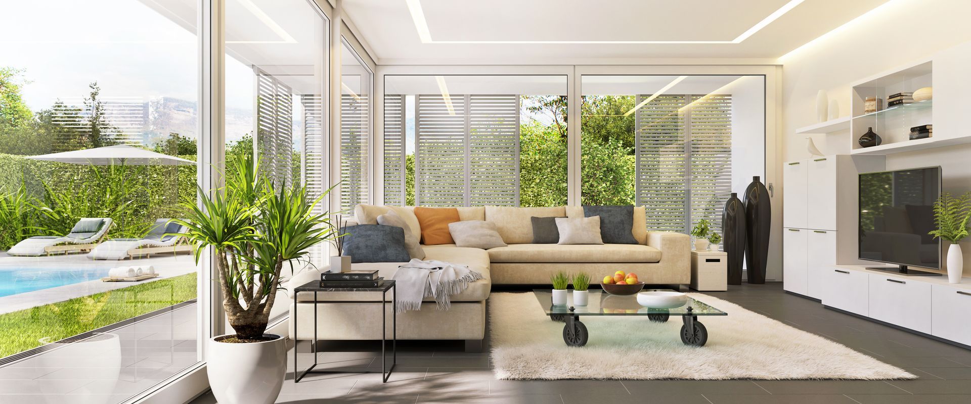 Salon moderne avec murs vitrés, vue sur la piscine, canapé d'angle et table basse en verre.