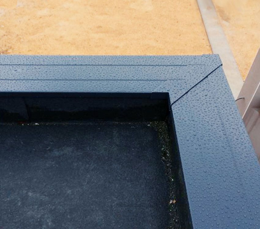 Gros plan sur le bord d'une piscine bleu-gris mouchetée, avec une eau sombre à l'intérieur et des carreaux beiges tout autour.