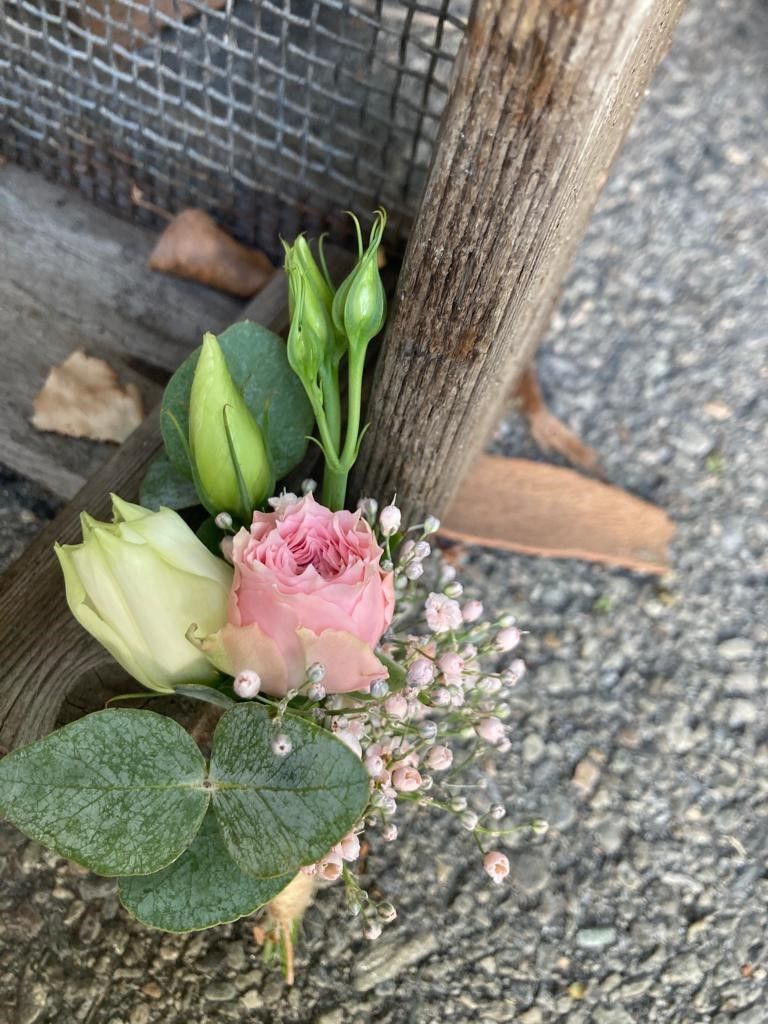 Eine Nahaufnahme eines Blumenstraußes auf einem Holzzaun.