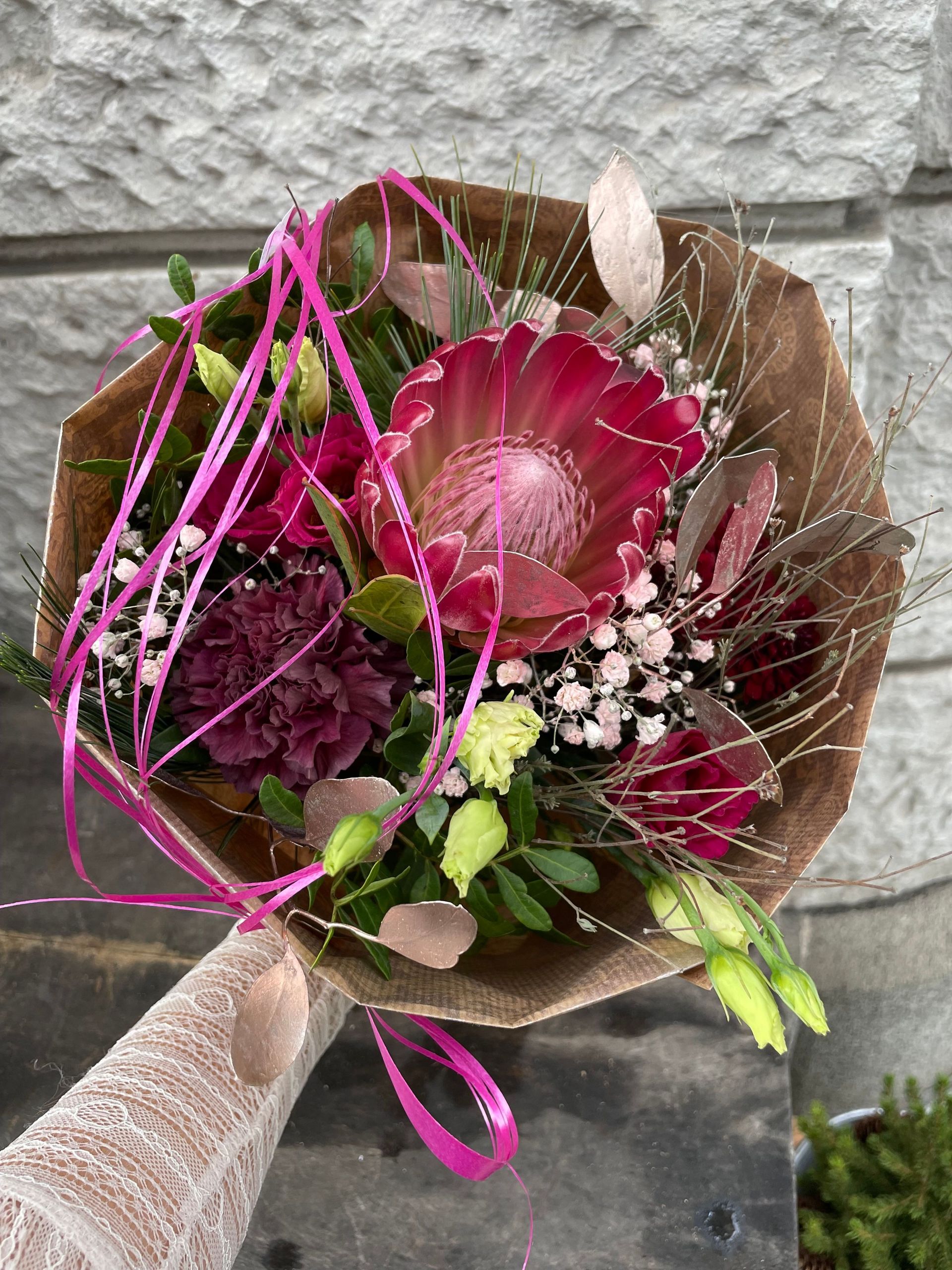 Eine Person hält einen Blumenstrauß in der Hand.