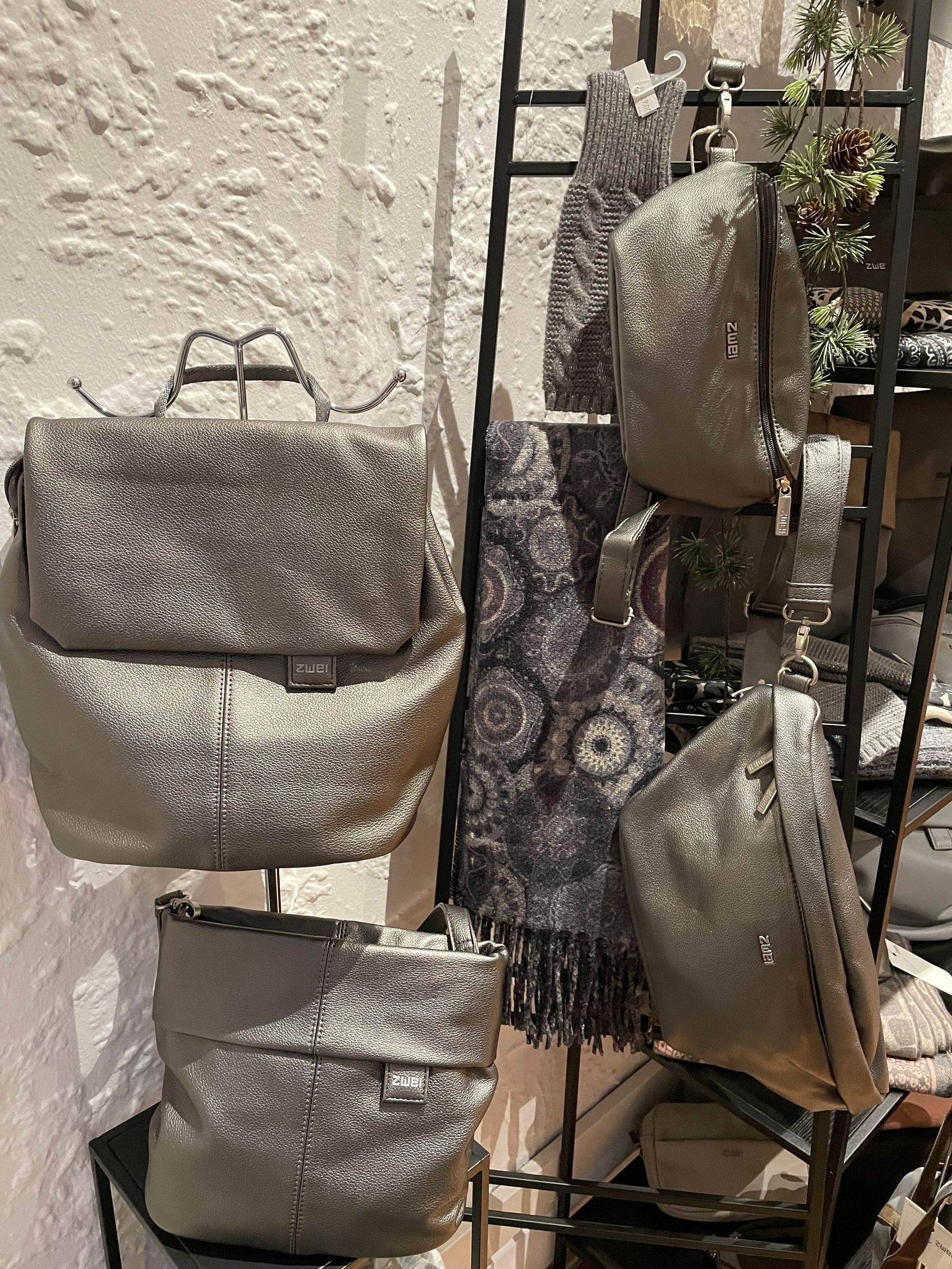 Ein Bündel silberner Säcke & Taschen hängt an einem Gestell.