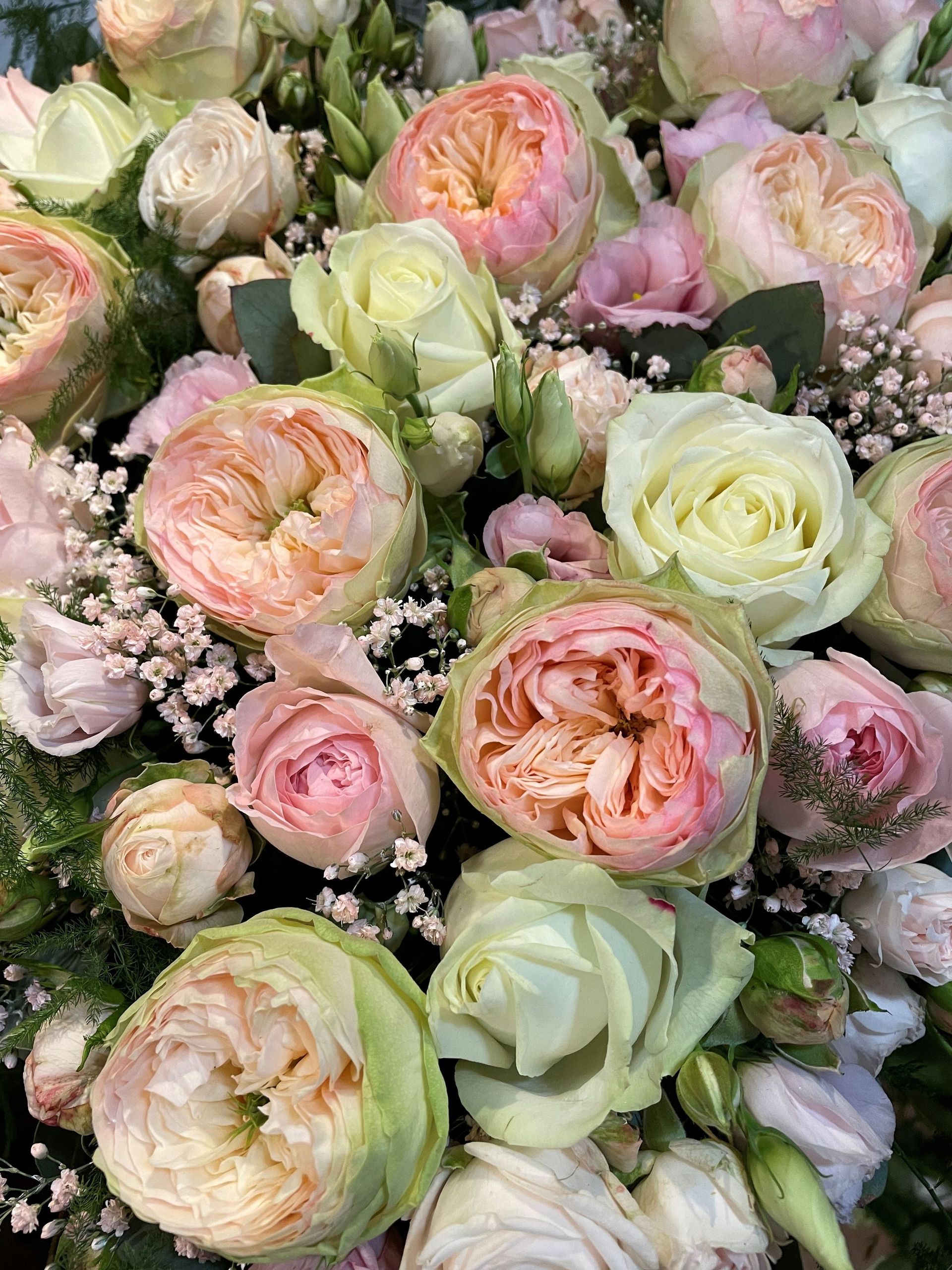 Eine Nahaufnahme eines Straußes rosa und weißer Rosen.