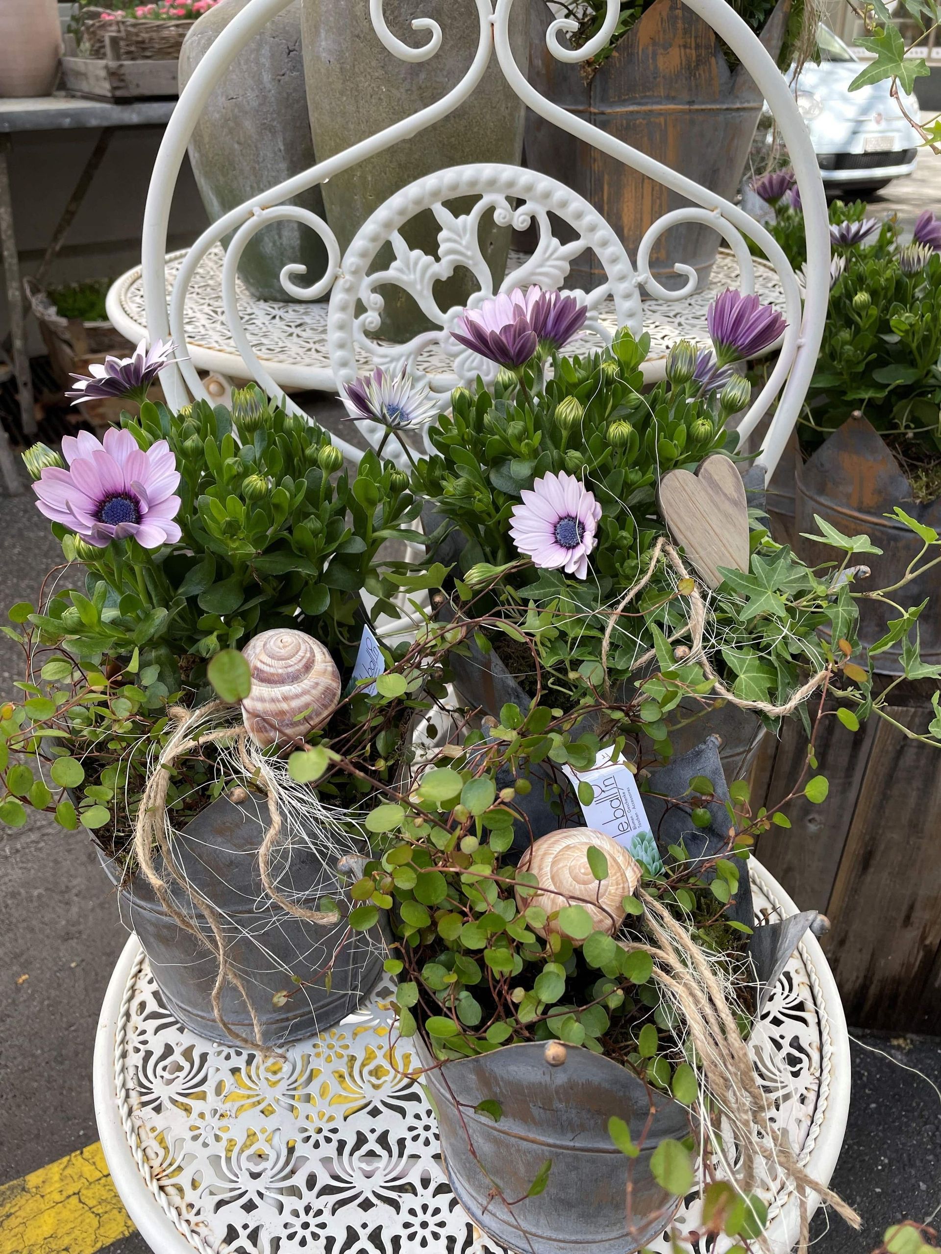 Ein weißer Stuhl mit Blumen in Töpfen darauf.