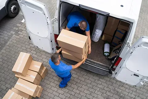 Dos hombres están cargando cajas en una camioneta.