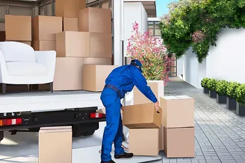Un hombre está cargando cajas en un camión de mudanzas.