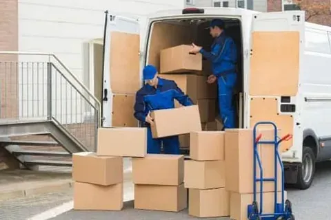 Dos hombres están cargando cajas en un camión de mudanzas.