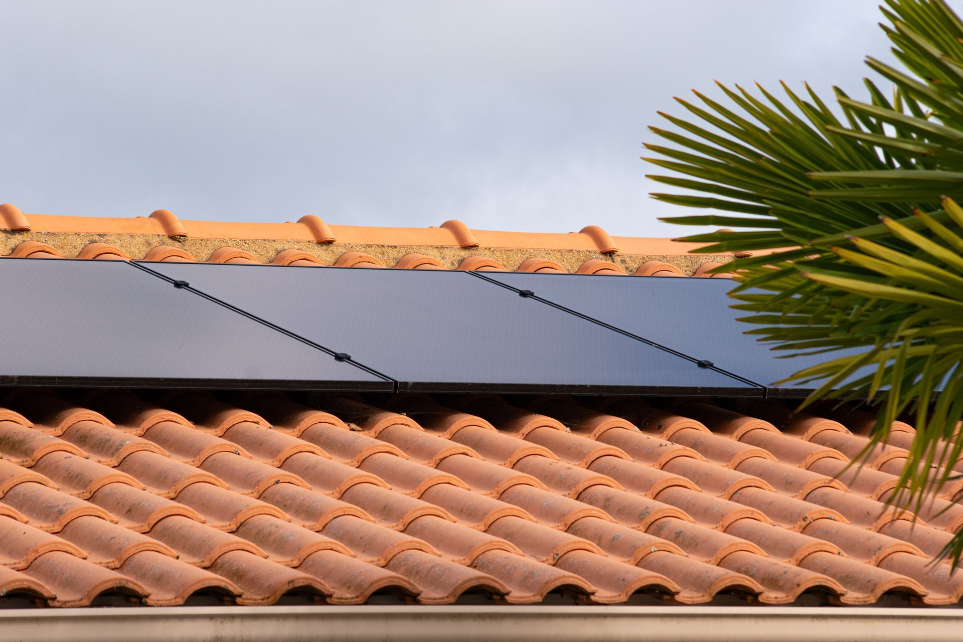Panneaux photovoltaïques sur un toit de tuiles en terre cuite.