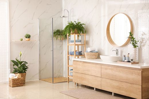 Une salle de bains lumineuse avec douche, meuble-vasque, miroir et lavabo.