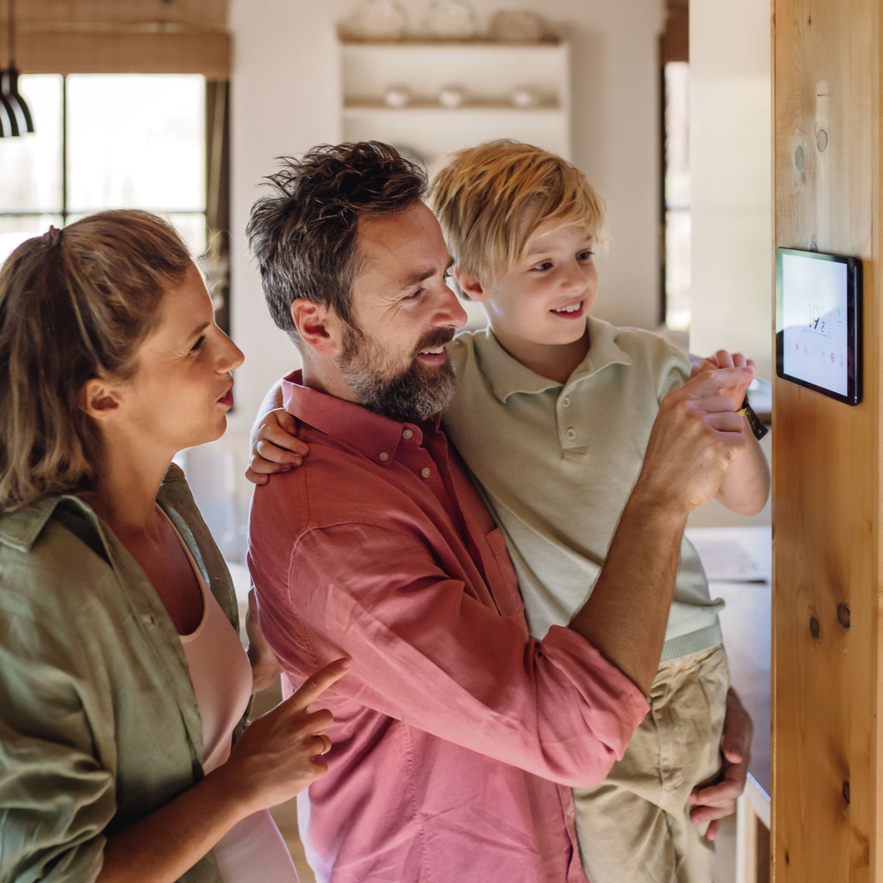 Une famille utilise ensemble unthermostat mural.