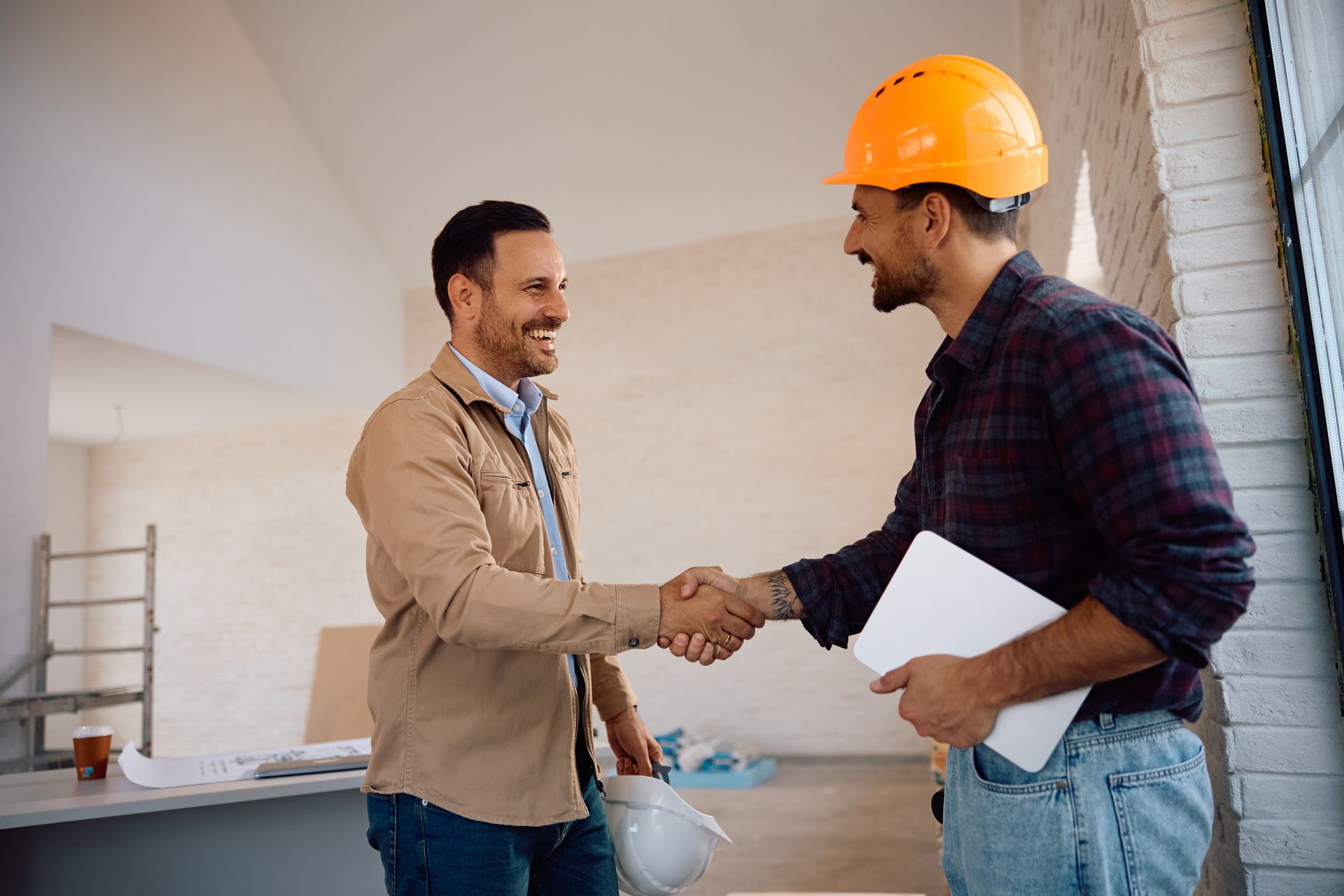Deux hommes se serrent la main sur un chantier.