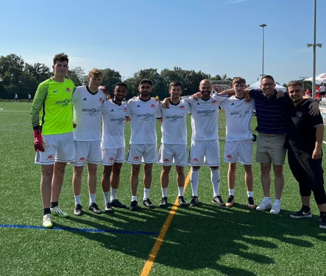 Eine Gruppe von Fußballspielern posiert für ein Foto auf einem Feld