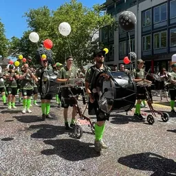 Eine Gruppe von Menschen marschiert in einer Parade eine Straße entlang.