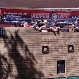 Eine Gruppe von Menschen steht vor einem Schild mit der Aufschrift „Reifen glatt“