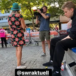 Ein Mann macht mit einer Kamera ein Foto von einer Frau.