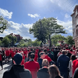 Eine Gruppe von Menschen in roten Hemden läuft eine Straße entlang.