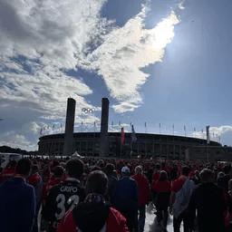 Eine Menschenmenge steht vor einem Stadion.
