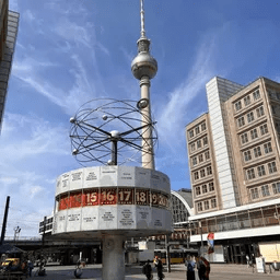Ein großer Uhrturm inmitten einer Stadt mit Gebäuden im Hintergrund.