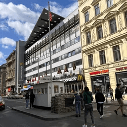 Eine Gruppe von Menschen läuft eine Straße vor einem McDonald's-Restaurant entlang.