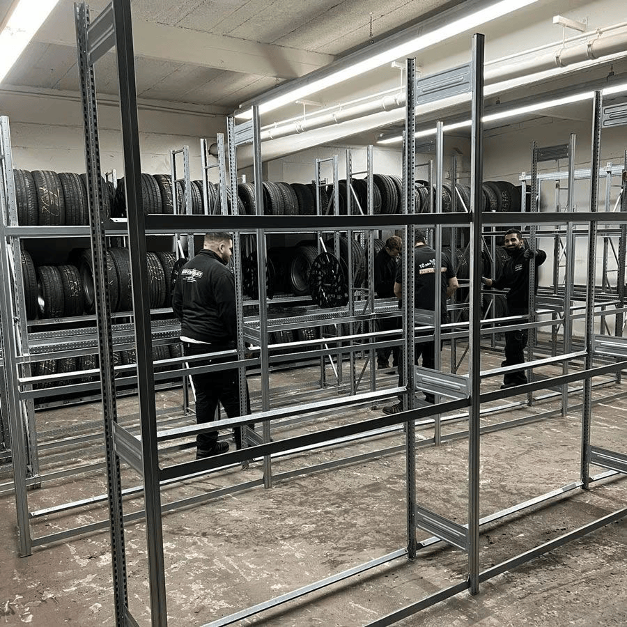 Zwei Männer arbeiten in einem Lagerhaus voller Reifen.