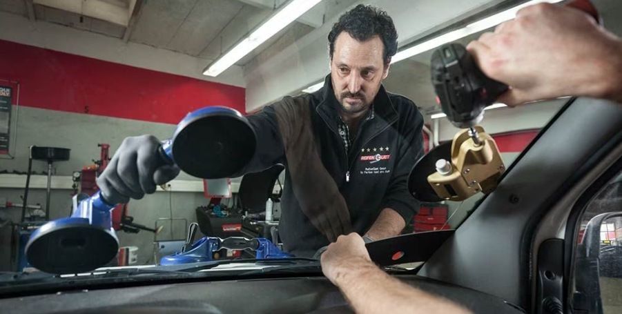 Zwei Mitarbeiter unseres Autoglas-Services in Lörrach tauschen eine Scheibe aus. 