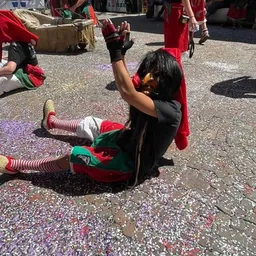 Eine Person in einem Clownskostüm liegt auf dem Boden