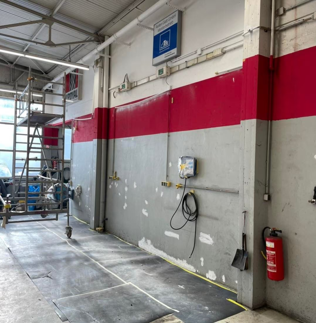 Ein roter Feuerlöscher hängt an einer Wand in einer Garage