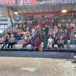 Eine große Gruppe von Menschen sitzt in einem Stadion und sieht sich eine Show an.