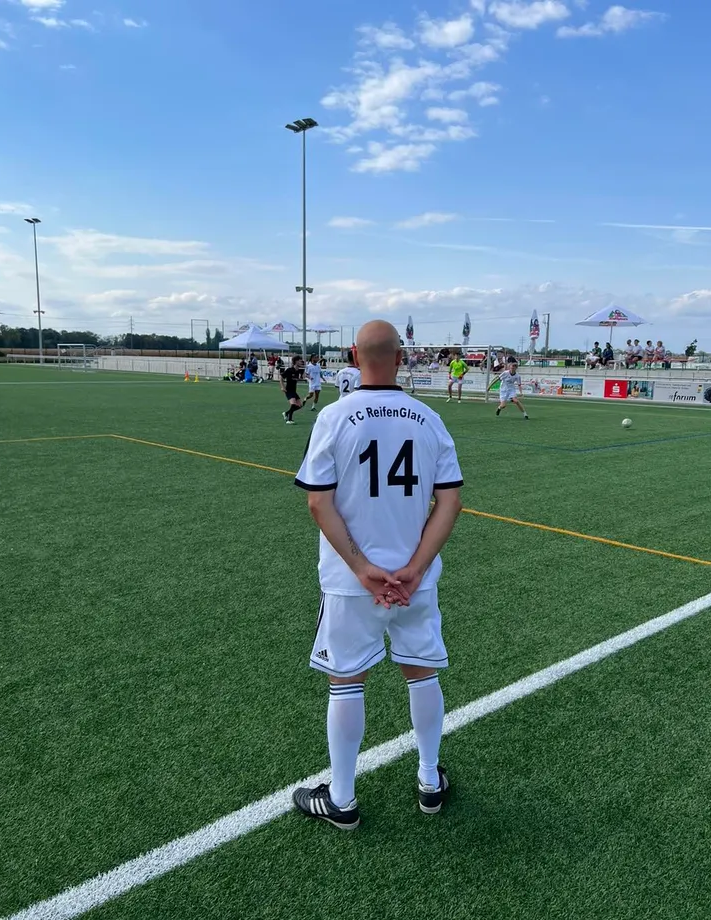 Ein Mann mit der Trikotnummer 14 steht auf einem Fußballfeld