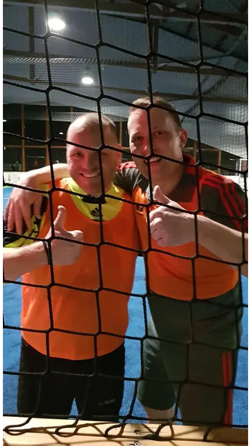 Zwei Männer posieren für ein Foto hinter einem Volleyballnetz