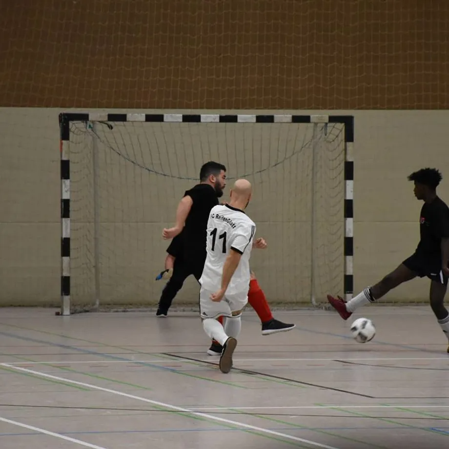 Ein Mann mit der Nummer 11 auf dem Rücken kickt einen Fußball