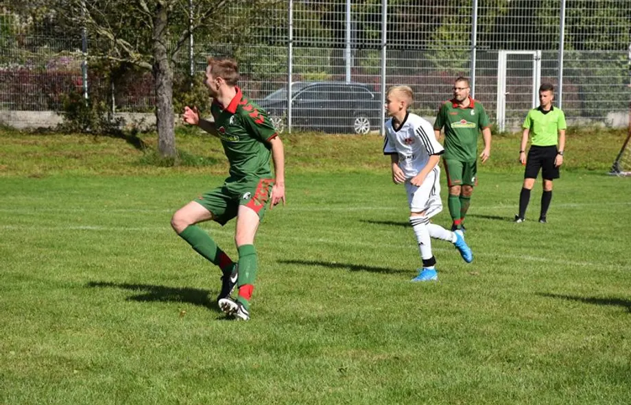 Eine Gruppe junger Männer spielt auf einem Feld Fußball.