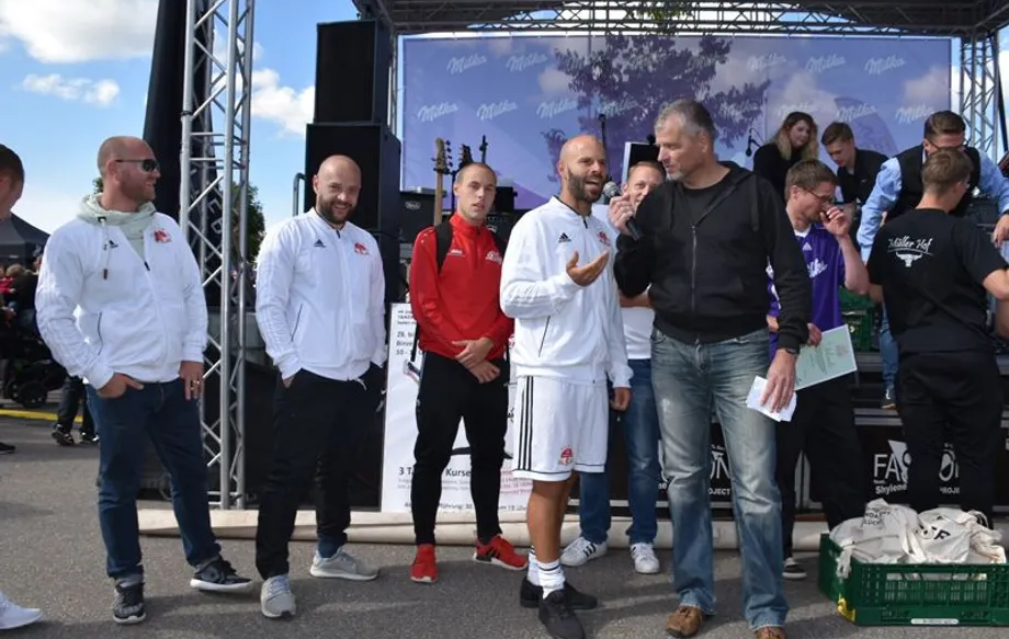 Eine Gruppe Männer steht vor einer Bühne.