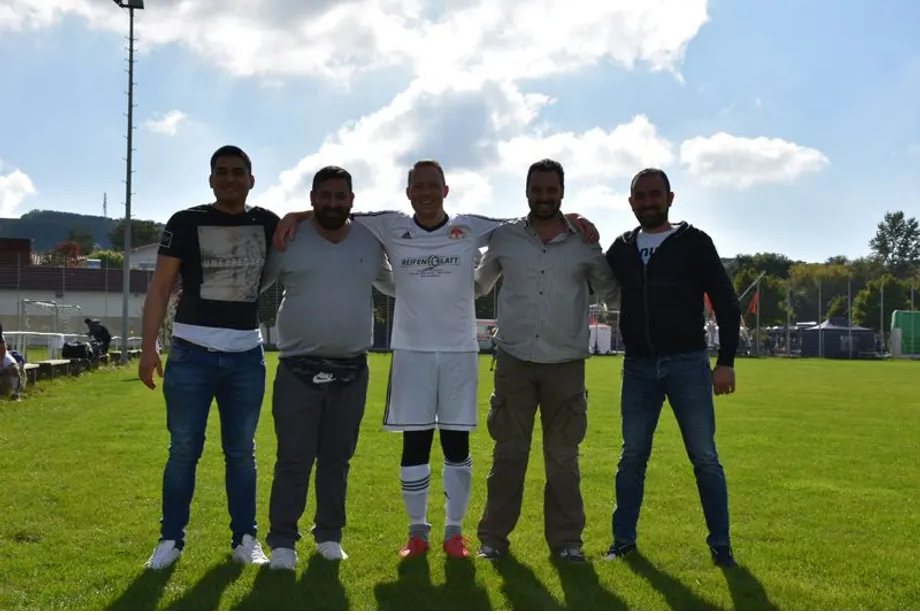 Eine Gruppe von Männern posiert für ein Foto auf einem Fußballfeld