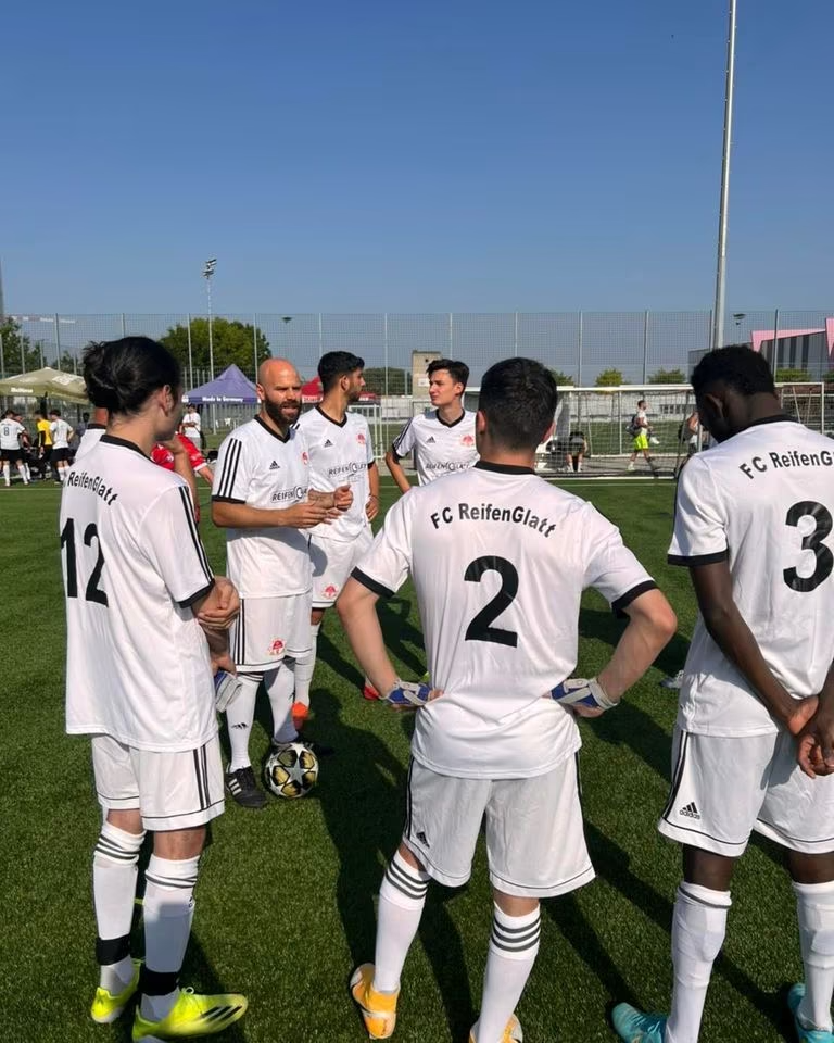 Eine Gruppe Fußballspieler steht auf einem Feld.