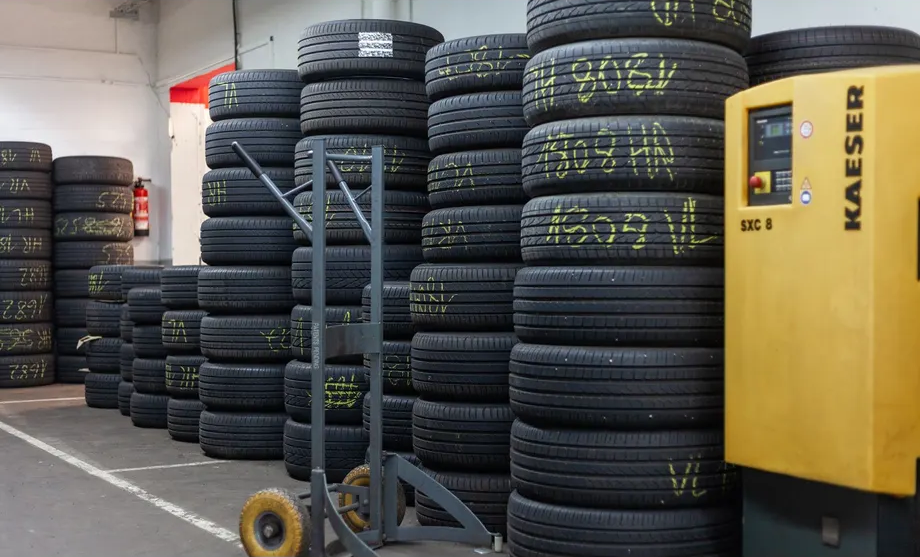 Ein Lager mit vielen Reifen und einem Kaeser-Luftkompressor
