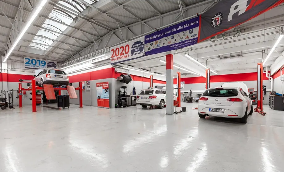 Ein Auto steht auf einer Hebebühne in einer Garage.